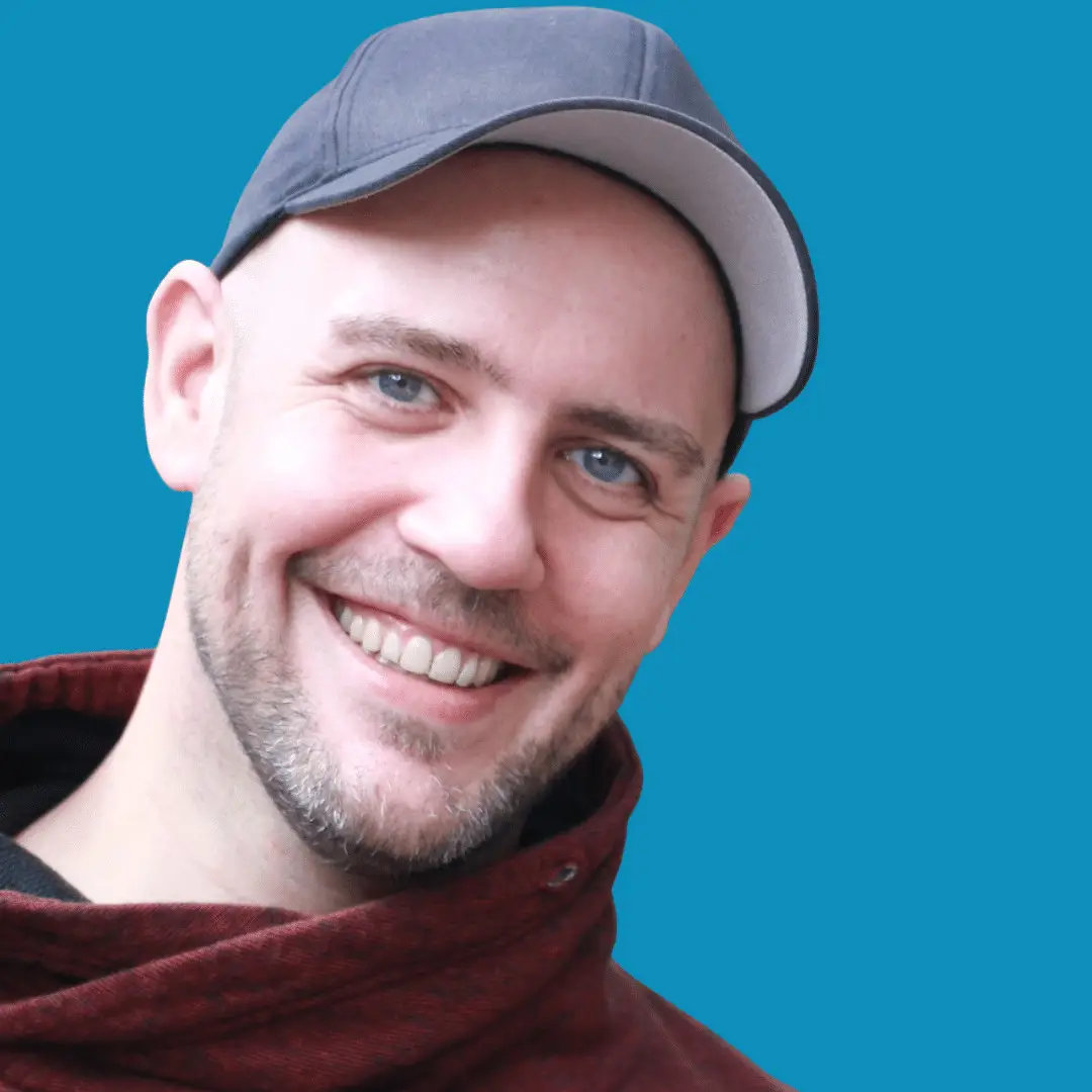 Thomas Lascheit lächelt vor einem blauen Hintergrund in die Kamera. Thomas Lascheit zeigt dir in seinen Workshops, wie du LAX VOX in der Stimmtherapie und der LaKru®-Stimmtransition anwendest.