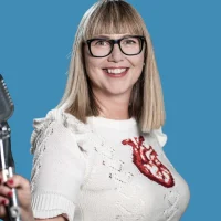 Anja Tipp, eine blonde Frau mit Pony, steht vor blauem Hintergrund